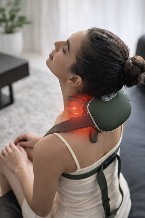 Femme utilisant masseur cervical shiatsu à domicile pour soulager tensions musculaires et stress